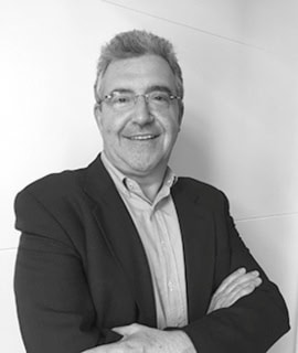 Hombre de negocios sonriendo con brazos cruzados en oficina.