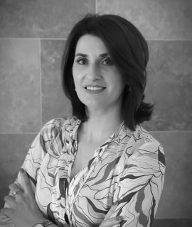 Mujer profesional en oficina con expresión confiada y amigable.